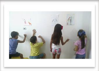 Crianças fazendo pintura mural.